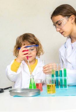 Test tüpleri, reaktörleri ve mikroskobu olan bir çocuğun laboratuvar incelemesi. Seçici odaklanma. çocuk.