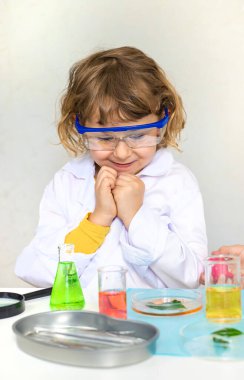 Test tüpleri, reaktörleri ve mikroskobu olan bir çocuğun laboratuvar incelemesi. Seçici odaklanma. çocuk.