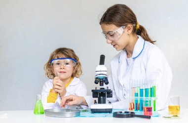 Test tüpleri, reaktörleri ve mikroskobu olan bir çocuğun laboratuvar incelemesi. Seçici odaklanma. çocuk.