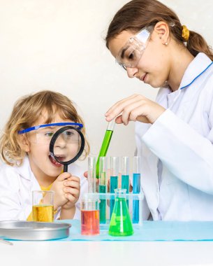 Test tüpleri, reaktörleri ve mikroskobu olan bir çocuğun laboratuvar incelemesi. Seçici odaklanma. çocuk.