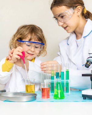 Test tüpleri, reaktörleri ve mikroskobu olan bir çocuğun laboratuvar incelemesi. Seçici odaklanma. çocuk.