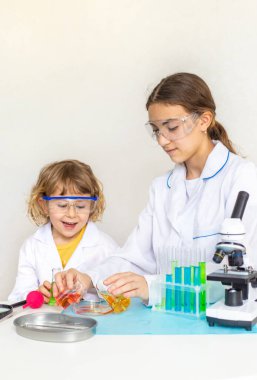 Test tüpleri, reaktörleri ve mikroskobu olan bir çocuğun laboratuvar incelemesi. Seçici odaklanma. çocuk.