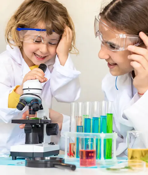 Test tüpleri, reaktörleri ve mikroskobu olan bir çocuğun laboratuvar incelemesi. Seçici odaklanma. çocuk.