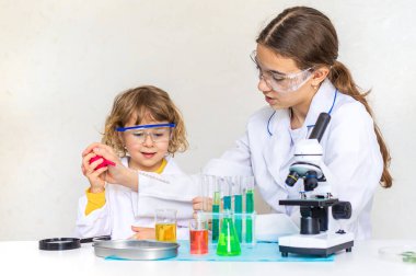 Test tüpleri, reaktörleri ve mikroskobu olan bir çocuğun laboratuvar incelemesi. Seçici odaklanma. çocuk.