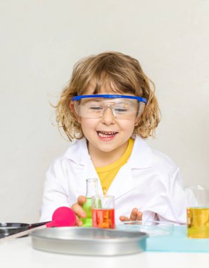 Test tüpleri, reaktörleri ve mikroskobu olan bir çocuğun laboratuvar incelemesi. Seçici odaklanma. çocuk.