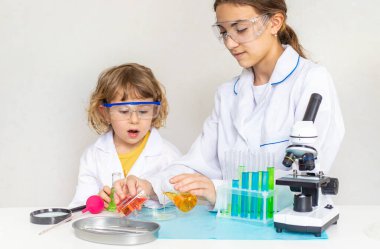 Test tüpleri, reaktörleri ve mikroskobu olan bir çocuğun laboratuvar incelemesi. Seçici odaklanma. çocuk.