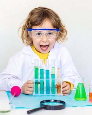 Test tüpleri, reaktörleri ve mikroskobu olan bir çocuğun laboratuvar incelemesi. Seçici odaklanma. çocuk.