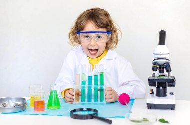 Test tüpleri, reaktörleri ve mikroskobu olan bir çocuğun laboratuvar incelemesi. Seçici odaklanma. çocuk.