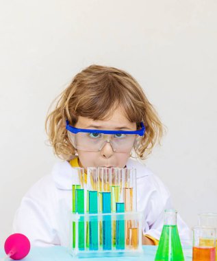 Test tüpleri, reaktörleri ve mikroskobu olan bir çocuğun laboratuvar incelemesi. Seçici odaklanma. çocuk.