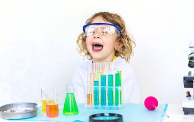 Test tüpleri, reaktörleri ve mikroskobu olan bir çocuğun laboratuvar incelemesi. Seçici odaklanma. çocuk.