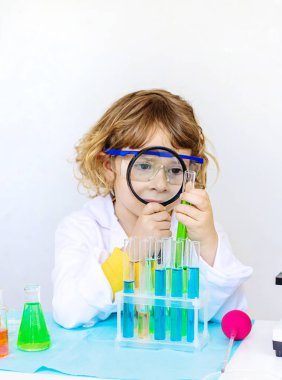 Test tüpleri, reaktörleri ve mikroskobu olan bir çocuğun laboratuvar incelemesi. Seçici odaklanma. çocuk.