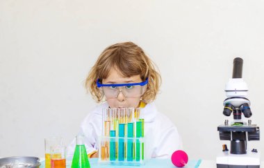 Test tüpleri, reaktörleri ve mikroskobu olan bir çocuğun laboratuvar incelemesi. Seçici odaklanma. çocuk.