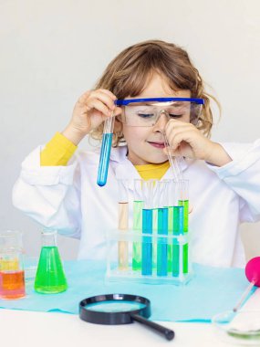Test tüpleri, reaktörleri ve mikroskobu olan bir çocuğun laboratuvar incelemesi. Seçici odaklanma. çocuk.