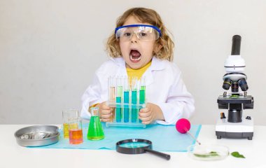 Test tüpleri, reaktörleri ve mikroskobu olan bir çocuğun laboratuvar incelemesi. Seçici odaklanma. çocuk.