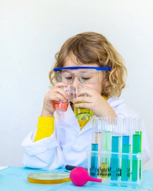 Test tüpleri, reaktörleri ve mikroskobu olan bir çocuğun laboratuvar incelemesi. Seçici odaklanma. çocuk.