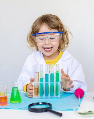 Test tüpleri, reaktörleri ve mikroskobu olan bir çocuğun laboratuvar incelemesi. Seçici odaklanma. çocuk.