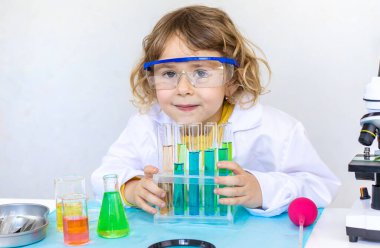 Test tüpleri, reaktörleri ve mikroskobu olan bir çocuğun laboratuvar incelemesi. Seçici odaklanma. çocuk.