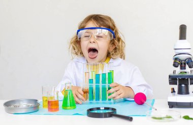 Test tüpleri, reaktörleri ve mikroskobu olan bir çocuğun laboratuvar incelemesi. Seçici odaklanma. çocuk.