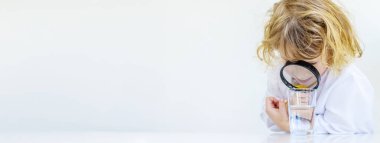 Bir çocuk suyu büyüteçle inceler. Seçici odaklanma. çocuk.