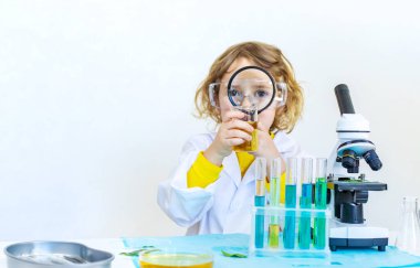 Test tüpleri, reaktörleri ve mikroskobu olan bir çocuğun laboratuvar incelemesi. Seçici odaklanma. çocuk.