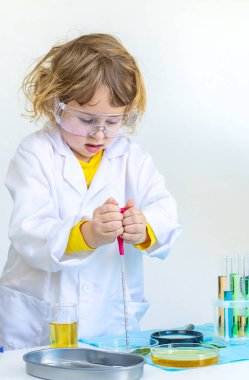 Test tüpleri, reaktörleri ve mikroskobu olan bir çocuğun laboratuvar incelemesi. Seçici odaklanma. çocuk.