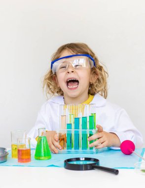 Test tüpleri, reaktörleri ve mikroskobu olan bir çocuğun laboratuvar incelemesi. Seçici odaklanma. çocuk.