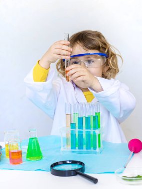 Test tüpleri, reaktörleri ve mikroskobu olan bir çocuğun laboratuvar incelemesi. Seçici odaklanma. çocuk.