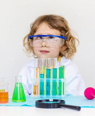 Test tüpleri, reaktörleri ve mikroskobu olan bir çocuğun laboratuvar incelemesi. Seçici odaklanma. çocuk.