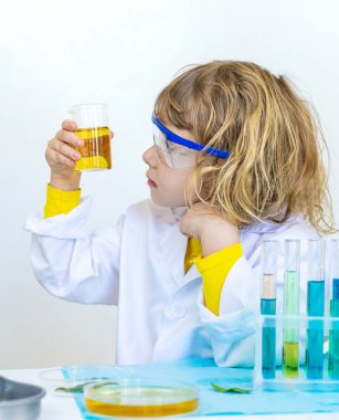 Test tüpleri, reaktörleri ve mikroskobu olan bir çocuğun laboratuvar incelemesi. Seçici odaklanma. çocuk.