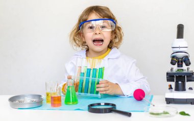 Test tüpleri, reaktörleri ve mikroskobu olan bir çocuğun laboratuvar incelemesi. Seçici odaklanma. çocuk.