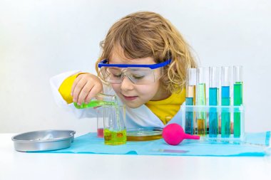 Test tüpleri, reaktörleri ve mikroskobu olan bir çocuğun laboratuvar incelemesi. Seçici odaklanma. çocuk.