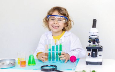 Test tüpleri, reaktörleri ve mikroskobu olan bir çocuğun laboratuvar incelemesi. Seçici odaklanma. çocuk.