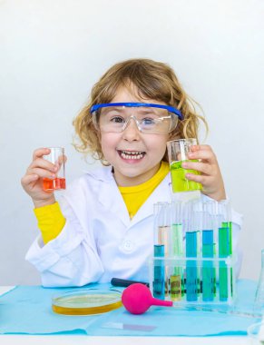 Test tüpleri, reaktörleri ve mikroskobu olan bir çocuğun laboratuvar incelemesi. Seçici odaklanma. çocuk.