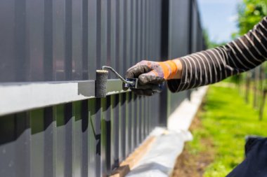 Metal çit boyayan bir adam. Seçici odaklanma. insanlar.