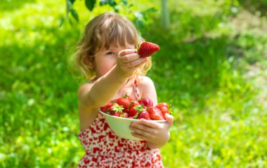 Bahçesinde çilek olan çocuk. Seçici odaklanma. Çocuk.