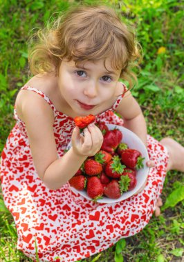 Bahçesinde çilek olan çocuk. Seçici odaklanma. Çocuk.