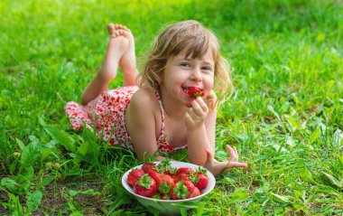 Bahçesinde çilek olan çocuk. Seçici odaklanma. Çocuk.