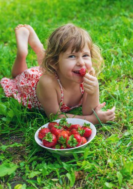 Bahçesinde çilek olan çocuk. Seçici odaklanma. Çocuk.