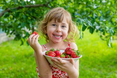 Bahçesinde çilek olan çocuk. Seçici odaklanma. Çocuk.
