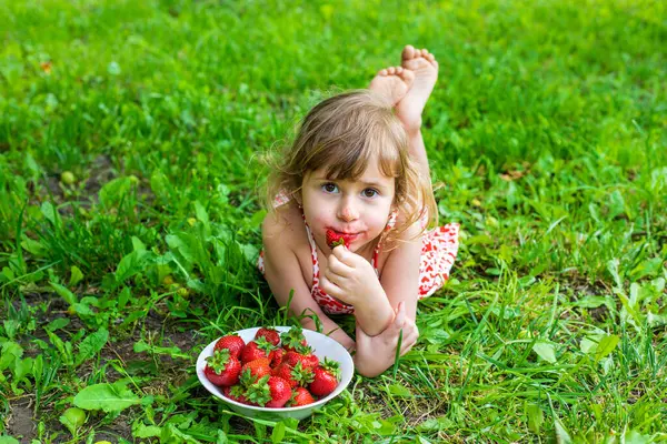 Bahçesinde çilek olan çocuk. Seçici odaklanma. Çocuk.
