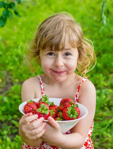 Bahçesinde çilek olan çocuk. Seçici odaklanma. Çocuk.