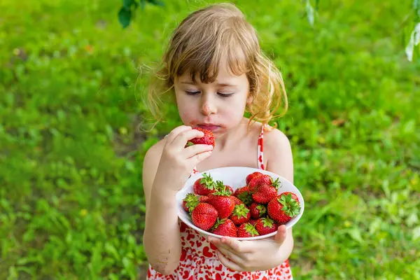 Bahçesinde çilek olan çocuk. Seçici odaklanma. Çocuk.