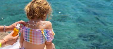 Çocuğun sırtında güneş kremi var. Seçici odaklanma. çocuk.