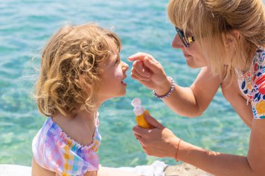 Çocuğun yüzünde güneş kremi var. Seçici odaklanma. çocuk.