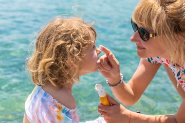 Çocuğun yüzünde güneş kremi var. Seçici odaklanma. çocuk.