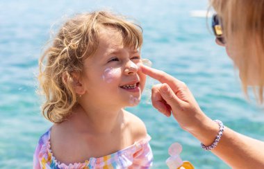 Çocuğun yüzünde güneş kremi var. Seçici odaklanma. çocuk.
