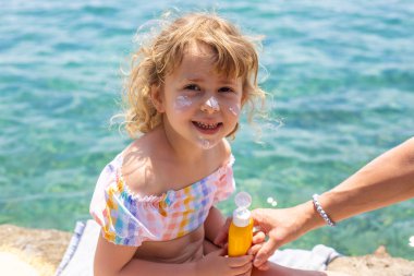 Çocuğun yüzünde güneş kremi var. Seçici odaklanma. çocuk.