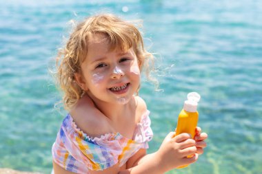 Çocuğun yüzünde güneş kremi var. Seçici odaklanma. çocuk.