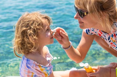 Çocuğun yüzünde güneş kremi var. Seçici odaklanma. çocuk.