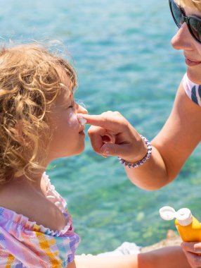 Çocuğun yüzünde güneş kremi var. Seçici odaklanma. çocuk.